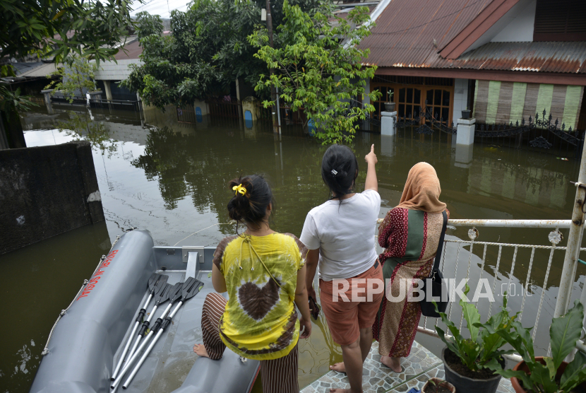 Warga memerhatikan rumahnya yang terendam banjir di Kecamatan Manggala, Makassar, Sulawesi Selatan, Kamis (11/3/2021). Curah hujan yang tinggi dalam beberapa hari di kawasan tersebut membuat kanal, sungai dan waduk di kota Makassar meluap sehingga mengakibatkan ratusan rumah dan jalan terendam banjir. 