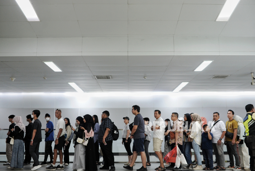 Penumpang mengantre untuk menempelkan kartu uang elektronik sebelum menaiki kereta MRT di Stasiun Bundaran HI, Jakarta, Ahad (23/6/2024). Kelas menengah memainkan peran penting dalam perekonomian.