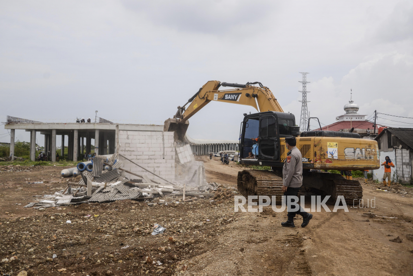 Alat berat merobohkan bangunan rumah saat pembebasan lahan proyek Jalan Tol (Foto: ilustrasi).