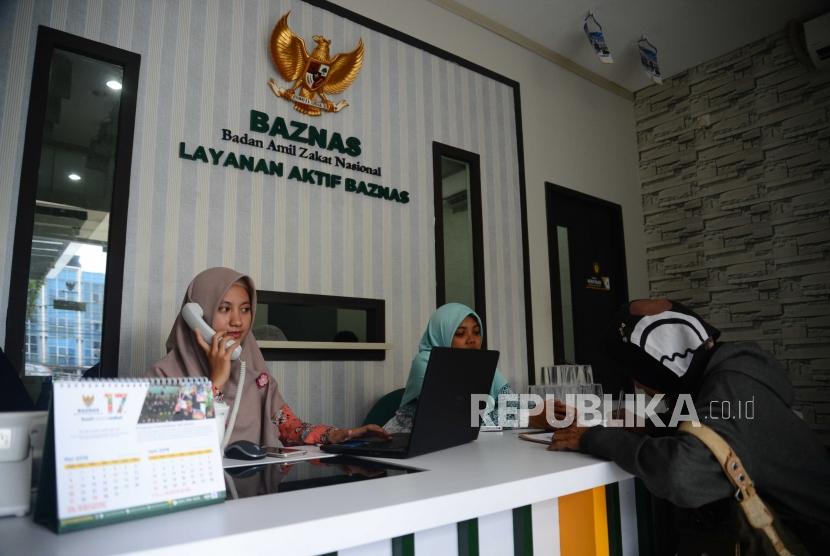 Petugas Badan Amil Zakat Nasional,melayani warga yang  datang ke kantor Baznas Tebet, Jakarta, Selasa (26/6).