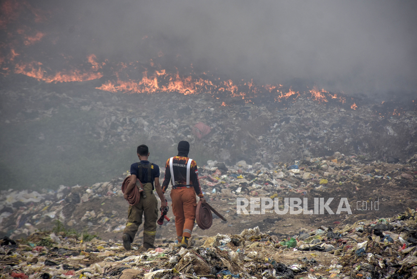 Petugas pemadam kebakaran membawa selang untuk penanganan kebakaran di TPA Sarimukti, Cipatat, Kabupaten Bandung Barat, Jawa Barat, Rabu (23/8/2023). 