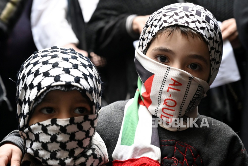 Anak-anak Palestina menutupi wajah mereka dengan keffiyeh tradisional selama protes di kamp pengungsi Palestina Burj Barajneh di pinggiran selatan Beirut, Lebanon, 5 Februari 2024. 