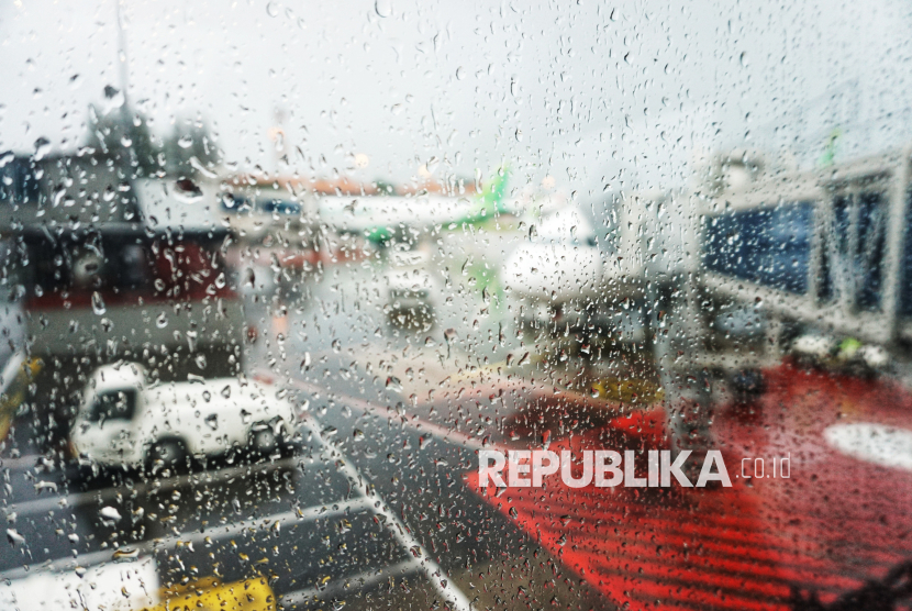Sejumlah pesawat dari berbagai maskapai tampak parkir di bawah guyuran hujan di apron Bandara Soekarno-Hatta, Tangerang, Banten, Selasa (18/11/2025).