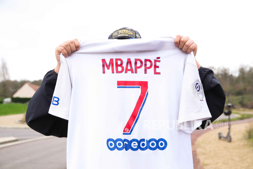  A fan poses with a Mbappe jersey near the PSG campus in Poissy, France, 16 February 2024. PSG striker Kylian Mbappe announced his departure at the end of the season.  