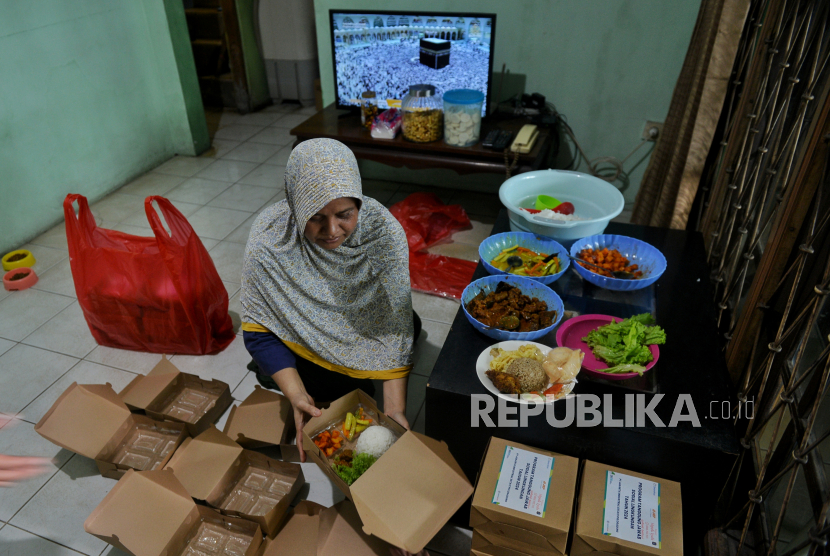 Hadjiah (54) pemilik UMKM Dapoer Mpok Iyah mengemas nasi box pesanan di rumahnya di kawasan Cakung, Jakarta Timur, Selasa (20/2/2024). UMKM Dapoer Mpok Iyah merupakan UMKM binaan PT Jakarta Industrial Estate Pulogadung (PT JIEP) yang menjual beragam jenis makanan seperti camilan stik bawang, nasi kebuli hingga melayani jasa catering. Pembinaan yang dilakukan PT JIEP berbuah hasil bagi usahanya, selain mendapatkan bantuan modal Ia juga mendapatkan pendampingan sertifikasi halal sehingga berdampak pada peningkatan omset hingga 50 persen dari Rp500 ribu per hari, kini Rp1 juta per hari.