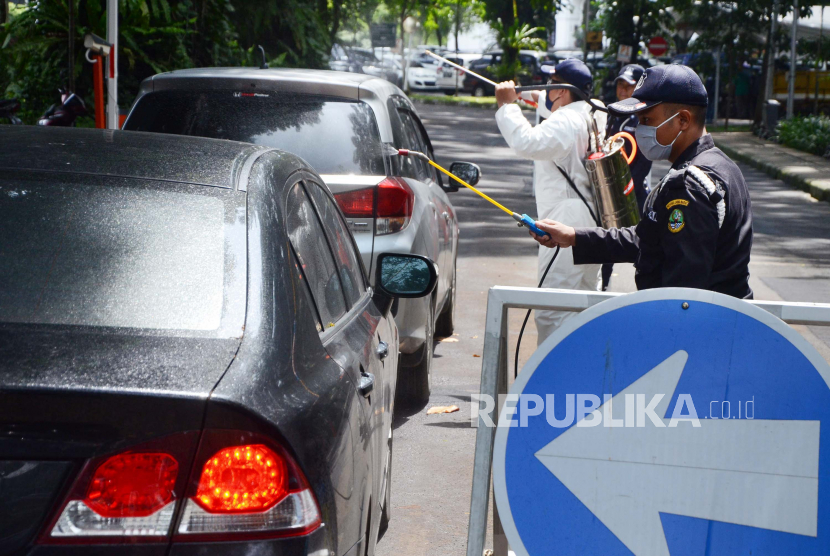 Petugas keamanan menyemprotkan desinfektan ke setiap kendaraan yang masuk komplek Gedung Sate, Kota Bandung, Senin (30/3). Penyemprotan dilakukan sebagai upaya mencegah penyebaran wabah Corona atau Covid-19