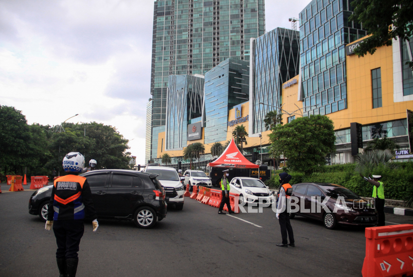 Petugas Dishub meminta kendaraan untuk berputar balik karena tidak berkepentingan saat ingin memasuki Kota Surabaya di Bundaran Waru, Surabaya, Jawa Timur, Ahad (10/5/2020). Pelaksanaan Pembatasan Sosial Berskala Besar (PSBB) Surabaya Raya yang meliputi, Kota Surabaya, Kabupaten Sidoarjo, dan Gresik diperpanjang sampai 25 Mei 2020 karena penyebaran virus Corona di Surabaya Raya dinilai masih massif