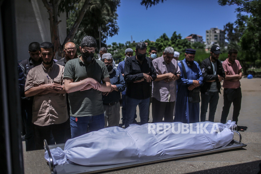 Warga Palestina berdoa di samping jenazah pejuang Hamas Hassan Salem selama pemakamannya di Kota Gaza pada 19 Mei 2021. 