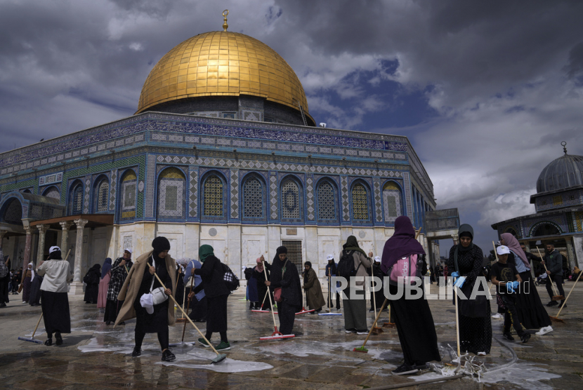 Relawan Palestina membersihkan tanah di luar Masjid Dome of Rock di kompleks Masjid Al-Aqsa menjelang bulan suci Ramadhan, di Kota Tua Yerusalem, Sabtu (18/3/2023).