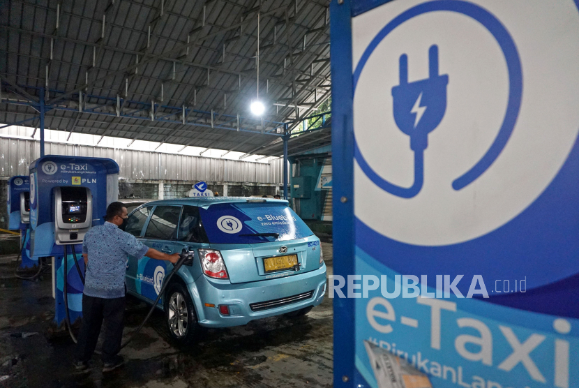 Pengemudi mengisi daya mobil taksi listrik Bluebird di Kantor Pusat Bluebird Group, Mampang, Jakarta, Rabu (13/7/2022). Hingga akhir tahun 2022 Bluebird menargetkan pertambahan hingga 50-60 unit armada listrik dengan fokus di Jakarta dan Bali.Prayogi/Republika.