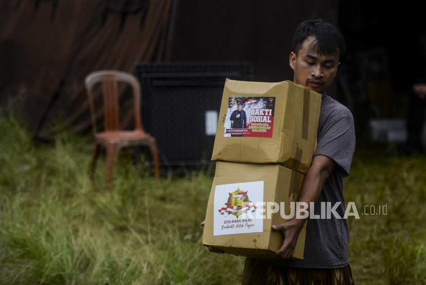 Seorang warga membawa bantuan dari kepolisian di kawasan Cijendil, Kecamatan Cugenang, Cianjur, Jawa Barat.
