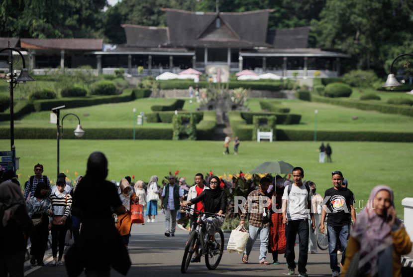 Pengunjung berwisata di Kebun Raya Bogor, Kota Bogor, Jabar, Jumat (30/6/2023). Jembatan Merah di Kebun Raya Bogor terkenal sebagai Jembatan Putus Cinta. Takhayul seperti itu banyak di objek wisata.