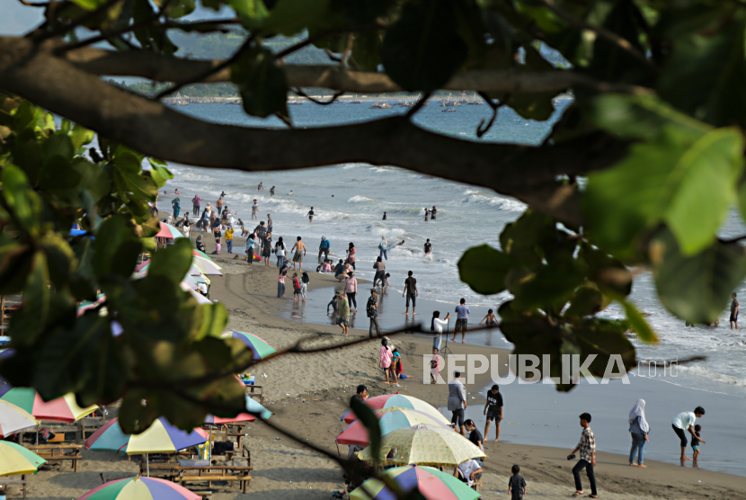 Wisatawan berlibur di kawasan Pantai Citepus, Palabuhanratu, Kabupaten Sukabumi, Jawa Barat, Ahad (24/12/2023). 