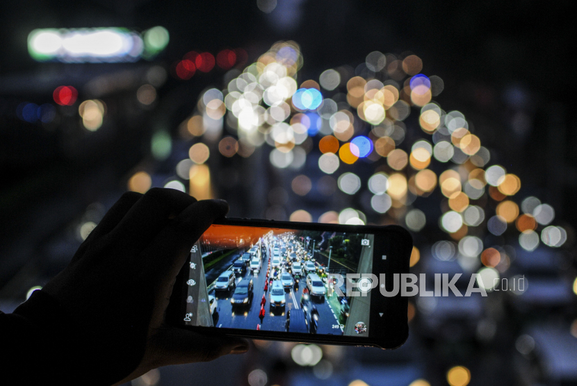 Warga memotret kendaraan terjebak kemacetan di kawasan Sudirman, Jakarta. Gubernur DKI Jakarta, Anies Rasyid Baswedan, mengatakan, saat ini kondisi Covid-19 di Jakarta semakin melandai dan berhasil memasuki PPKM level 1.