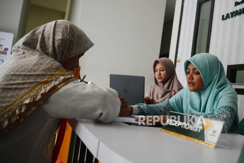 Petugas Badan Amil Zakat Nasional,melayani warga yang  datang ke kantor Baznas Tebet, Jakarta, Selasa (26/6).