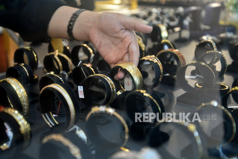 Karyawan menunjukkan perhiasan emas yang dijual di Galeri 24 Pegadaian, Jakarta, Selasa (19/7/2022). Harga emas berjangka sedikit menguat pada akhir perdagangan Kamis (15/6/2023).