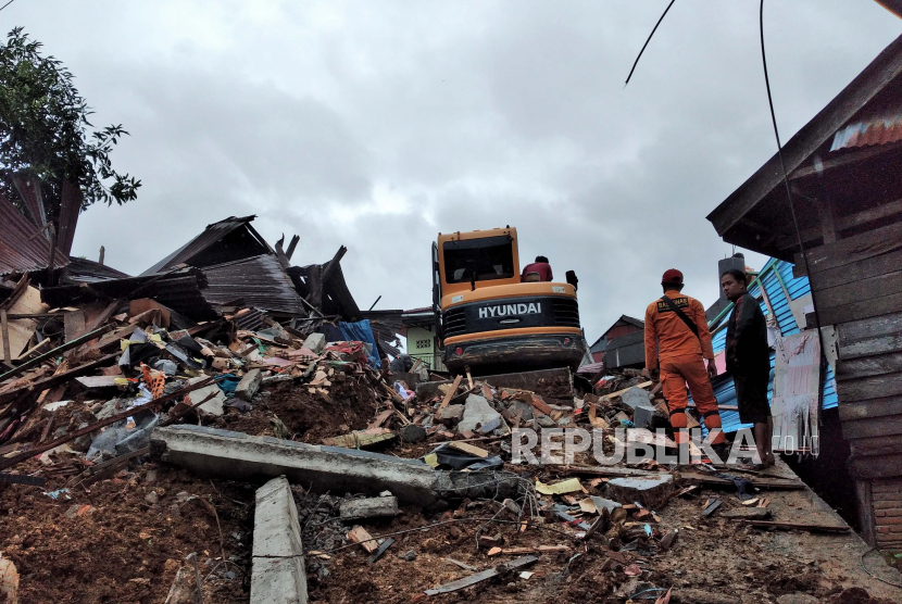  Tim penyelamat mencari yang selamat di antara reruntuhan bangunan yang rusak akibat gempa bumi di Mamuju, Sulawesi Barat,  Jumat (15/1/2021). 