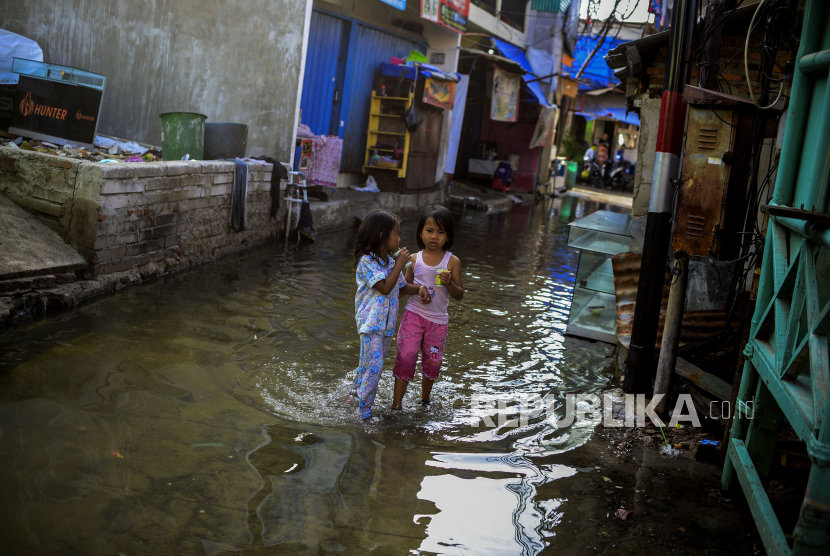 Anak-anak melintasi genangan air pasca terjadinya banjir rob di kawasan Muara Angke, Jakarta (ilustrasi)
