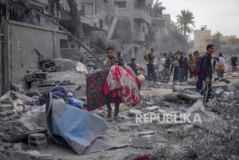 Warga Palestina menyaksikan kehancuran akibat bombardir Israel di Jalur Gaza, Palestina, di Deir al Balah, Rabu (22/11/2023).
