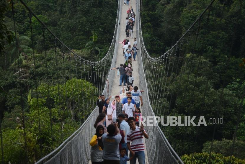 Wisatawan  berswafoto  di  Situ Gunung Suspension Bridge di Taman Nasional Gunung Gede Pangrango, Kadudampit, Sukabumi, Selasa (19/6). Pendakian ke Gunung Gede Pangrango belum dipastikan kapan akan dibuka.