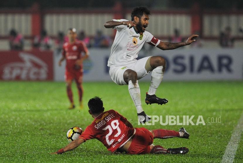 Pemain Persebaya Fandry Imbiri berusaha melewati hadangan pemain Persija Jakarta Sandi Sute dalam laga lanjutan Liga 1 2018 di Stadion PTIK, Jakarta Selatan, Selasa (26/6).