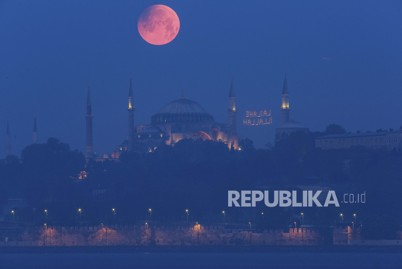  Bulan purnama muncul di atas Haghia Sophia yang ikonik di Istanbul, Turki, Senin pagi, 16 Mei 2022.