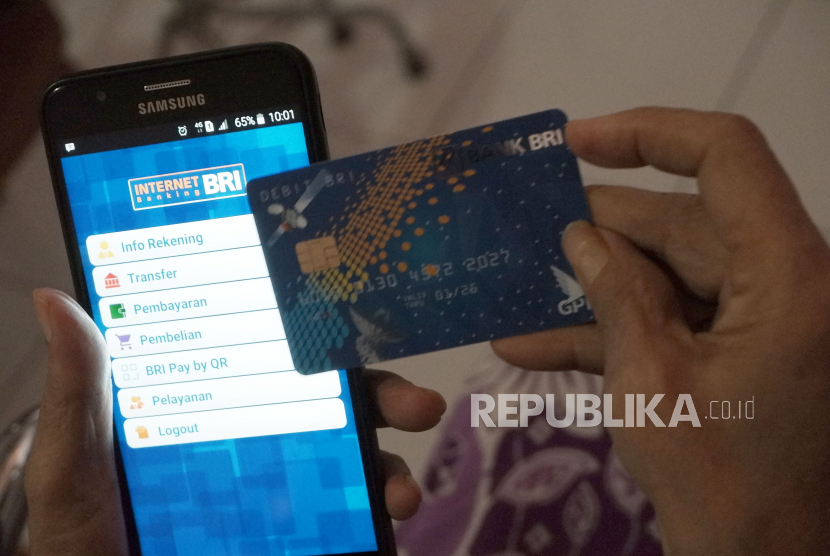 Seorang pensiunan PNS memperlihatkan kartu ATM milik Bank Rakyat Indonesia (BRI) yang baru diterimanya oleh petugas bank di Medan, Sumatera Utara, pekan lalu. PT Bank Rakyat Indonesia (Persero) Tbk mencatat kenaikan transaksi digital di tengah pandemi Covid-19, termasuk tarik tunai melalui ATM.