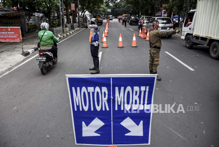 Petugas gabungan mengatur arus lalu lintas di pos pemeriksaan Pembatasan Sosial Berskala Besar (PSBB) di Jalan Rajawali, Kota Bandung, Senin (4/5). Pembatasan Sosial Berskala Besar (PSBB) Bandung Raya akan berakhir pada Selasa (5/5)
