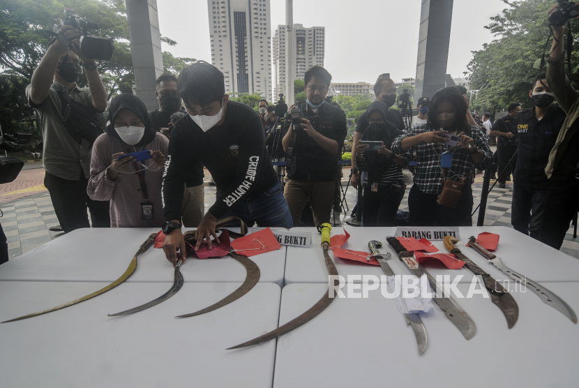 Polisi merapikan barang bukti senjata tajam saat konferensi pers. Polisi menangkap 6 remaja membawa senjata tajam usai terlibat tawuran di Pasar Minggu.
