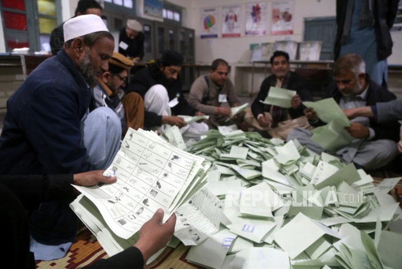 Petugas pemungutan suara menghitung surat suara di TPS saat pemilihan umum berakhir, di Peshawar, Pakistan, (8/2/2024).