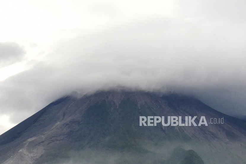 Puncak Gunung Merapi tertutup awan terlihat dari lapangan Umbulharjo, Kecamatan Cangkringan, Kabupaten Sleman, DI Yogyakarta, Jumat (29/1).