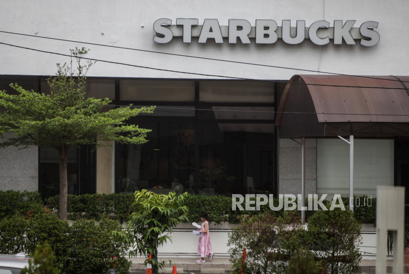 Warga berjalan di dekat gerai Starbucks di Jalan MH Thamrin, Jakarta, Ahad (5/11/2023). 
