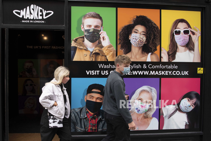  Pejalan kaki berjalan melewati toko yang menjual masker pelindung wajah di London, Inggris, 12 Oktober 2020. Inggris menjadi salah satu negara di Eropa yang berada dalam ancaman gelombang terbaru wabah Covid-19.