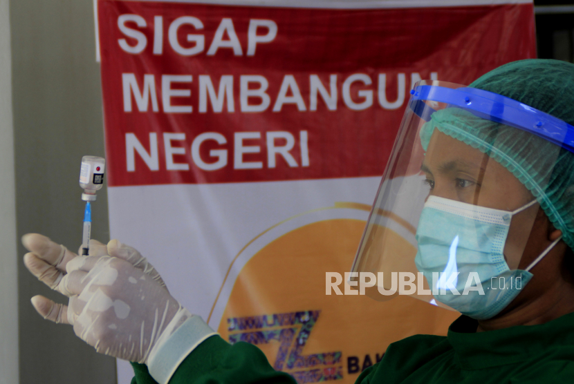 Vaksinator memasukan vaksin COVID-19 ke dalam suntikan saat vaksinasi dosis pertama bagi pegawai Kementerian PUPR di Kota Kupang, NTT, Kamis (25/3). Kamar Dagang dan Industri (Kadin) Indonesia terus mendorong program vaksinasi Gotong Royong. 