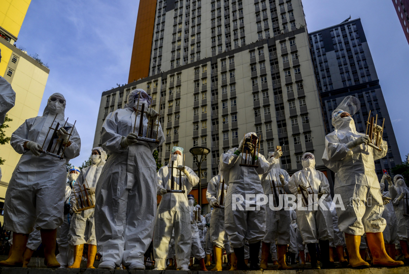 Sejumlah tenaga kesehatan memainkan angklung di RSDC Wisma Atlet, Kemayoran, Jakarta, Selasa (23/3). Acara tersebut dilakukan dalam rangka peringatan satu tahun beroperasinya RSDC Wisma Atlet Kemayoran dan mengenang tenaga kesehatan yang sudah gugur selama masa pandemi Covid-19. Republika/Putra M. Abar