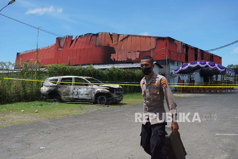 Seorang petugas polisi berdiri di luar klub malam yang dibakar di Sorong, provinsi Papua Barat, Indonesia, Selasa, 25 Januari 2022. 