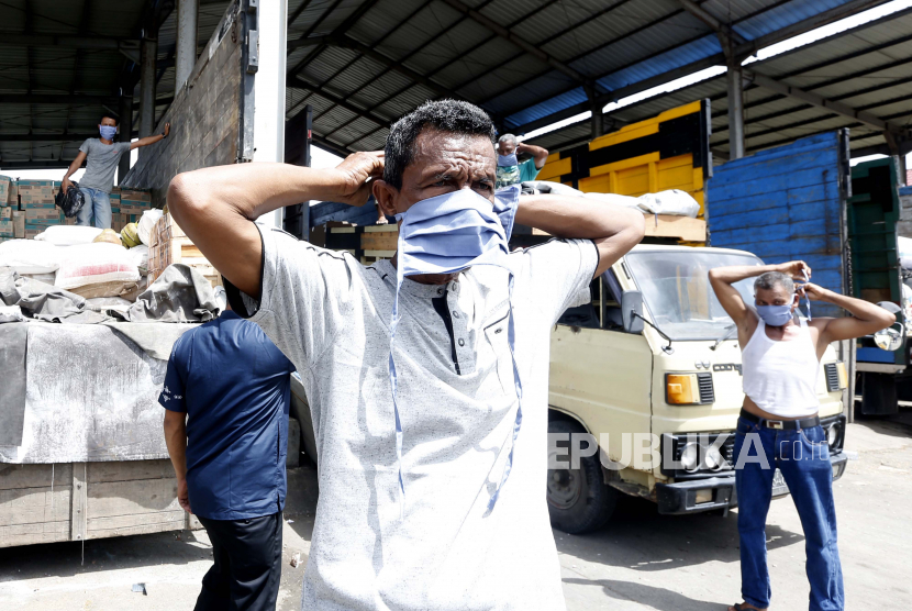 Para buruh bongkar muat memakai masker bantuan Pemerintah Kota Banda Aceh di terminal barang Santan, Aceh Besar, Aceh, Jumat (1/5/2020). Bantuan masker dari Pemerintah Kota Banda Aceh kepada para pekerja bongkar muat barang sebagai upaya mencegah dan memutus rantai penyebaran COVID-19 sekaligus memperingati Hari Buruh Internasional