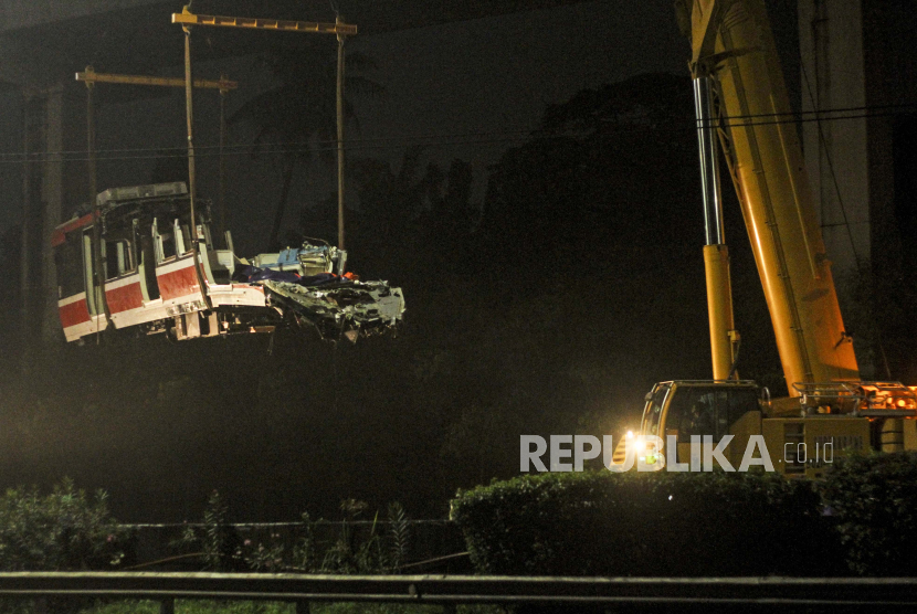 Petugas melakukan evakuasi penurunan gerbong kereta LRT yang mengalami kecelakaan di Ruas Cibubur - Ciracas, Jakarta Timur, Selasa (2/11/2021) dini hari. 