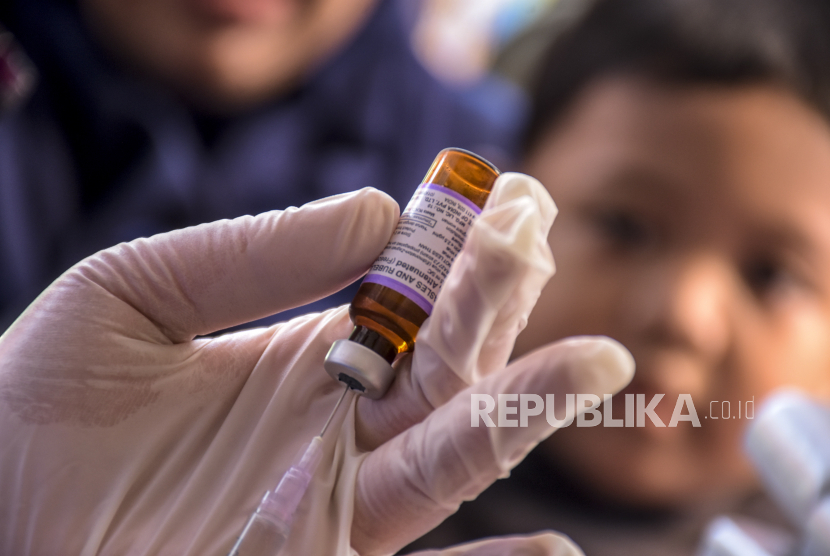 Petugas kesehatan menyiapkan vaksin measles rubella (MR) untuk disuntikkan kepada anak saat kegiatan Bulan Imunisasi Anak Nasional di halaman Masjid At Taqwa, Sukajadi, Kota Bandung, Selasa (2/8/2022). Sebagian dari vaksin masa kecil bisa memberikan perlindungan hingga anak dewasa, bahkan seumur hidup.