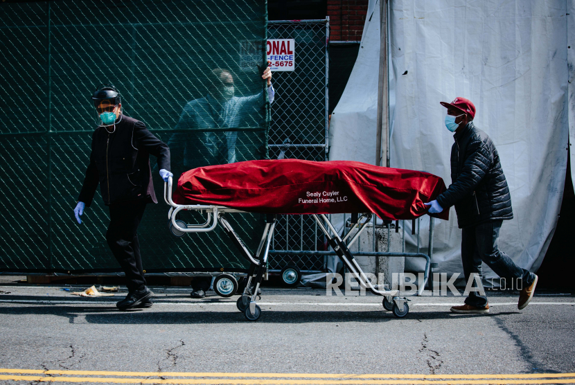 Pegawai rumah sakit dan pegawai layanan pemakaman memindahkan jenazah dari kamar mayat sementara di luar Pusat Rumah Sakit Brooklyn di Brooklyn, New York, AS, Rabu (8/4). Rakyat AS yang tinggal di rumah membantu mengurangi pasien baru Covid-19. Ilustrasi.