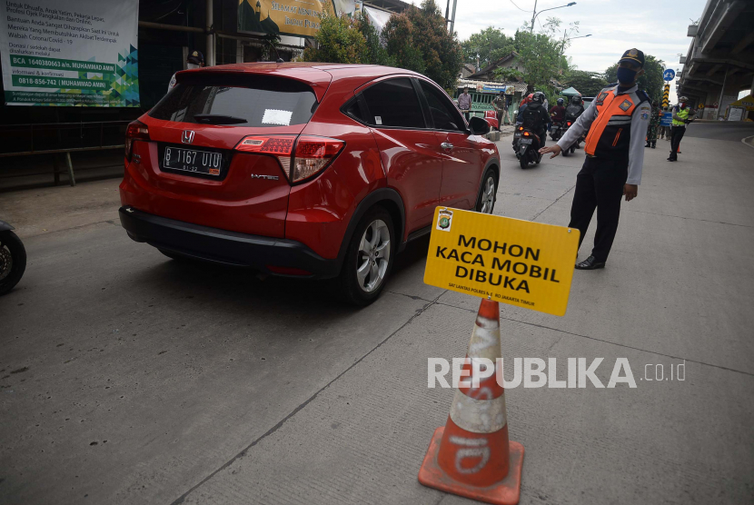 Petugas melakukan pengawasan kepada pengendara dengan plat nomor luar daerah yang melintasi Check Point PSBB di Kalimalang, Jakarta, Selasa (26/5). Warga pemudik yang hendak kembali ke DKI Jakarta dan sekitarnya seharusnya melalui tes Covid-19. 