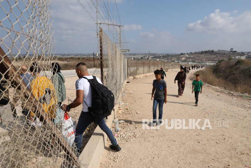 Warga Palestina menyeberang melalui bagian terbuka penghalang pemisahan Israel yang kontroversial di dekat kota Tepi Barat Tulkarem untuk mencapai Israel, 04 Agustus 2020. 