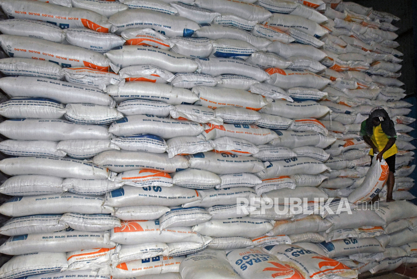 Pekerja mengangkut beras saat proses penyaluran beras ke pasar-pasar di Gudang Perum BULOG.