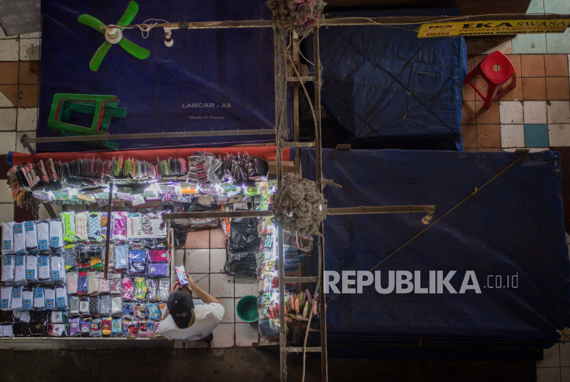 Aktivitas pedagang saat pemberlakuan sistem ganjil-genap di Pasar Perumnas Klender, Jakarta Timur, Senin (15/6). 