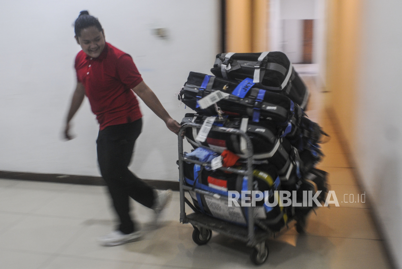 Petugas membawa koper calon jamaah haji di Asrama Haji Pondok Gede, Jakarta, Rabu (8/6/2022). Dua Jamaah Haji Asal Nganjuk Meninggal Jelang Keberangkatan