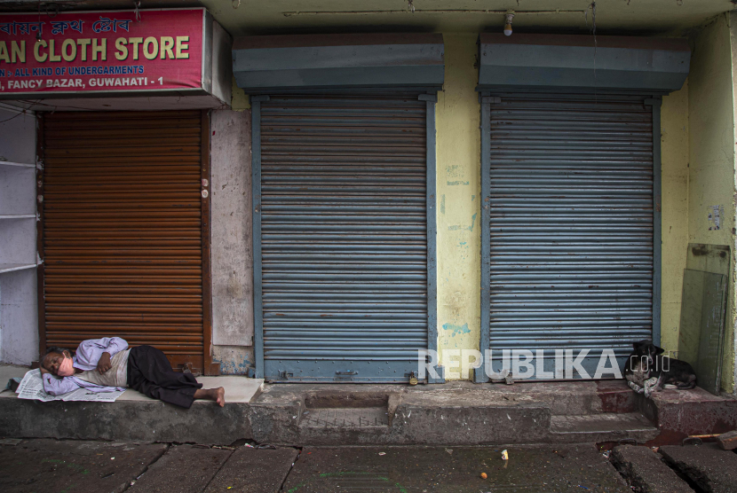 Seorang tuna wisma tidur dengan mengenakan masker di depan toko yang tutup di Gauhati, India (ilustrasi)