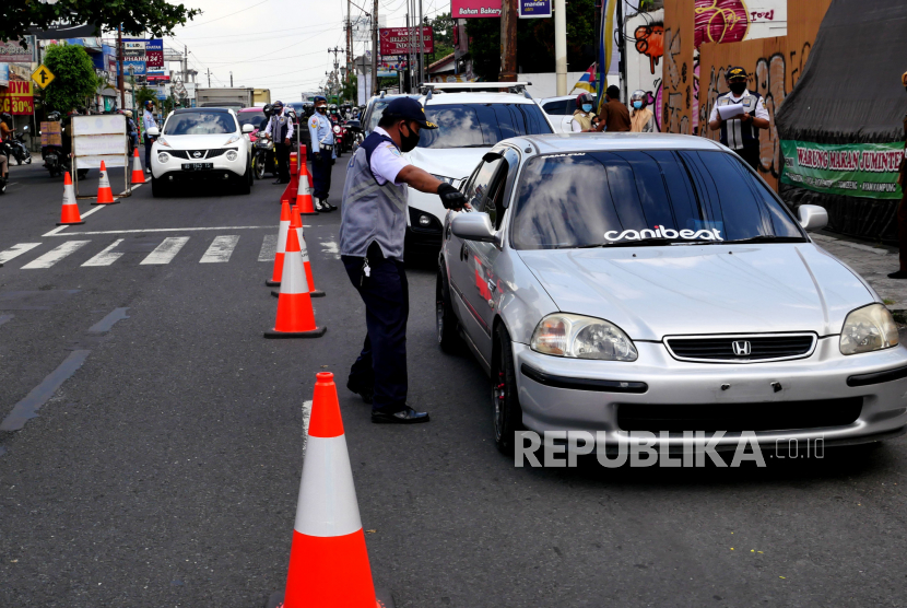Petugas gabungan melakukan razia nonyustisi PPKM Level 4 di Batas Kota Yogyakarta, Rabu (28/7). Pada operasi ini petugas gabungan memeriksa kartu vaksinasi Covid-19 bagi warga dengan kendaraan berplat nomor luar Yogyakarta. Selain itu, juga ditanya keperluan masuk ke Yogyakarta.