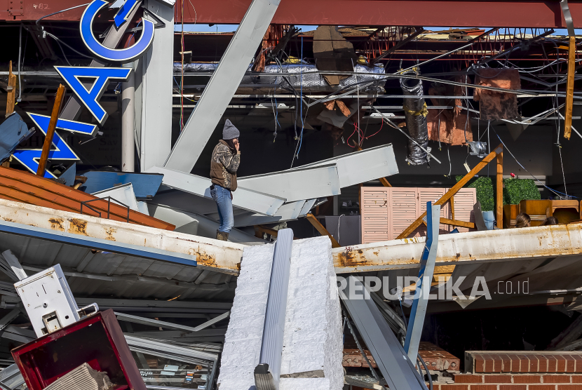 Warga mengamati kerusakan sebuah bisnis setelah tornado mematikan melanda di Mayfield, Kentucky, AS, Ahad (12/12) 2021. Sebanyak 70 orang dikhawatirkan tewas di Kentucky akibat wabah tornado, menurut Gubernur Kentucky Andy Beshear.
