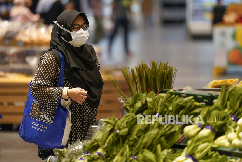  Seorang pembelanja yang mengenakan masker untuk membantu mengekang penyebaran virus corona melihat produk dan toko kelontong di Putrajaya, Malaysia, Senin, 5 Oktober 2020. 