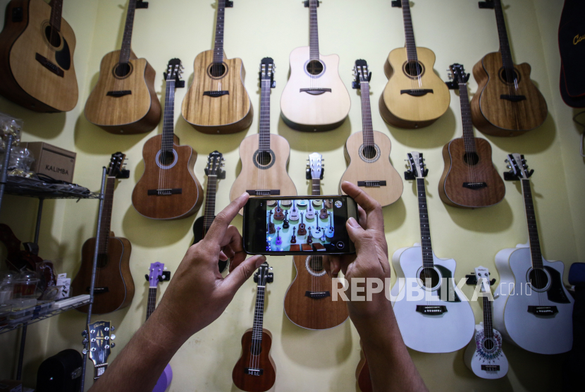 Pedagang gitar rumahan memotret barang dagangannya untuk dijual secara daring di Ciledug, Tangerang, Banten, Senin (20/7/2020). Saat ini sudah sekitar 10,2 juta atau 16 persen pelaku UMKM yang memanfaatkan teknologi digital